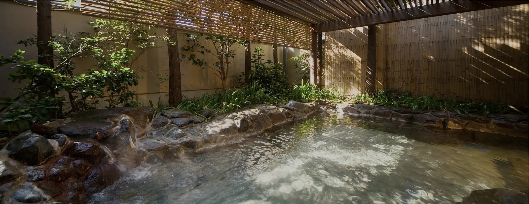 自然光が差し込む岩風呂の露天温泉