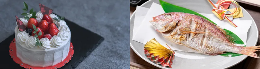 苺と生クリームを飾ったホールケーキと、祝いの飾りを添えた鯛の塩焼きを並べた料理