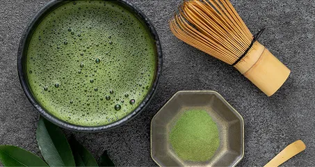 黒い湯のみで供された日本茶と茶葉