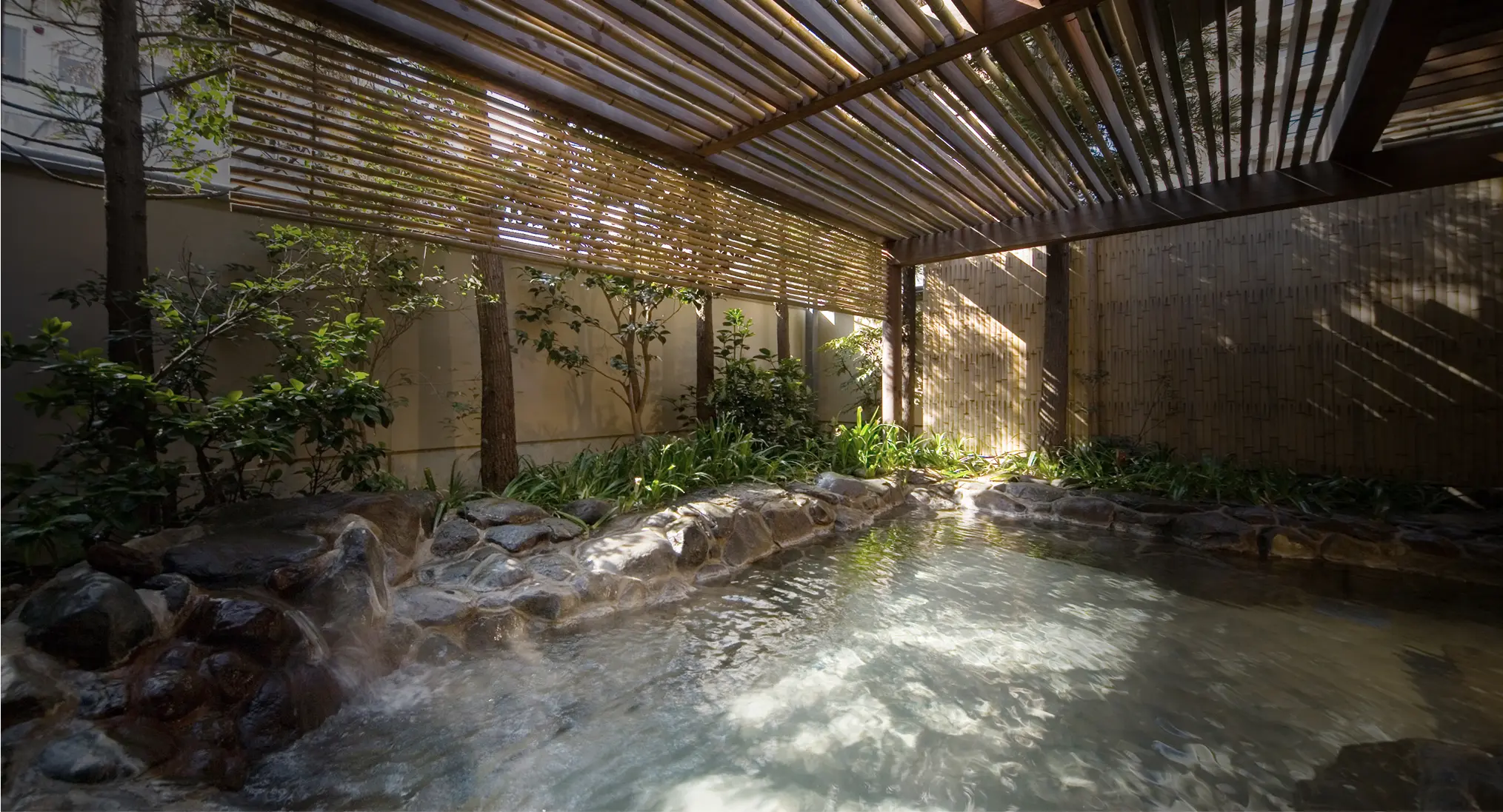 庭園に面した露天風呂と竹垣の景色